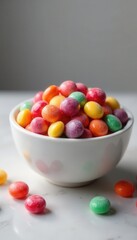 A polished marble bowl overflows with jewel-toned hard candies , elegant, tabletop