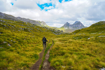 Obraz premium Female hiker enjoying view on Prutas Peaks trail with Mount Sedlo in the distance 