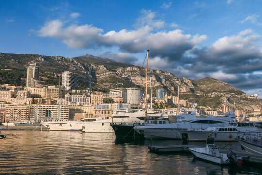 Monaco, Monaco - January 11, 2025: Luxury yachts docked in the harbor with Monacos skyline and mountains in the background
