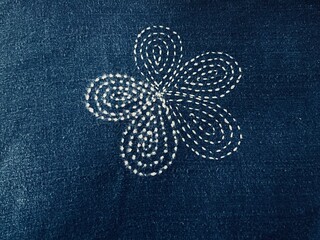 Blue indigo fabric with embroidered flower pattern.