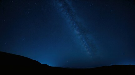 Fototapeta premium Majestic night sky with countless bright stars, Milky Way stretching across, dark mountain silhouette on the horizon, deep blue celestial view, peaceful and mysterious atmosphere.