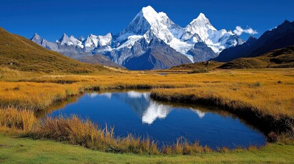Fototapeta premium Majestic Snow-Capped Mountains Reflecting in Tranquil Blue Lake Surrounded by Golden Grassland