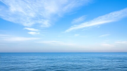 Obraz premium Serene Ocean Scene Under a Blue Sky with Wispy Clouds