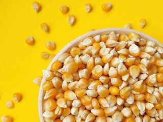 Big portion of corn seeds on a yellow background.