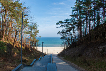 Scenic Stairway Leading to a Sandy Beach with Blue Sea and Sky in Jastrzębia Góra