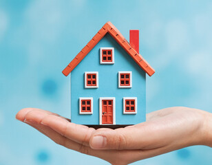 Hand h&auml;lt sch&uuml;tzend ein Miniatur Haus