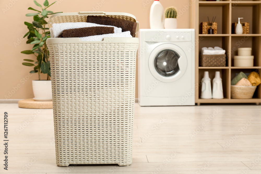 Wall mural Wicker basket full of laundry in bathroom