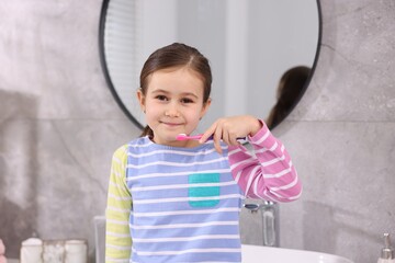 Fototapeta premium Cute girl with toothbrush in bathroom. Personal hygiene