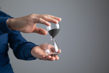 Caucasian businessman showing hourglass. Time management