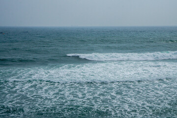Sea Waves Rolling Across the Ocean, Creating Energy and Motion, with Sunlight Sparkling on the Water's Surface.