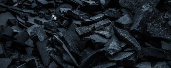 Black volcanic stone. Surface of basalt or granite close-up. Dark rough and textured rock.