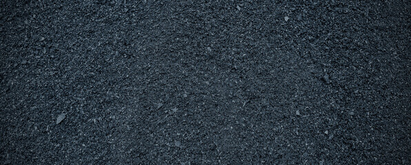 Black volcanic stone. Surface of basalt or granite close-up. Dark rough and textured rock.