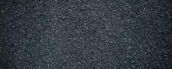 Black volcanic stone. Surface of basalt or granite close-up. Dark rough and textured rock.
