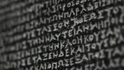 The Rosetta Stone, ancient stele inscribed with three scripts, key to deciphering Egyptian hieroglyphs. Macro close-up footage. Exhibit in museum.