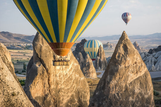 Hot air balloons flying over volcanic rock formations and fairy chimneys in Cappadocia, Turkey