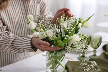 Young woman setting table for dinner at home, closeup