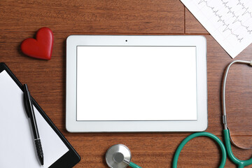 Cardiology. Flat lay composition with stethoscope and tablet on wooden table