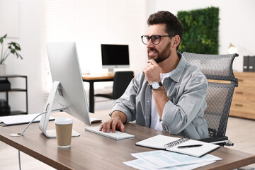 Man working on computer at table in office