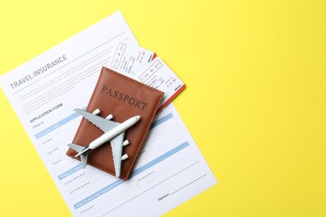 Medical tourism. Travel insurance application form, passport with tickets and airplane model on...