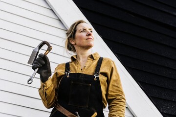 Empowering female blacksmith crafting metalwork in a scandinavian workshop portrait photography capturing strength and skill in an artisan environment