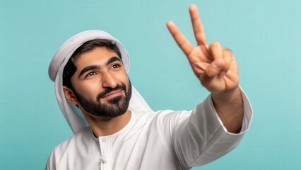 Fototapeta premium Smiling man in traditional middle eastern attire showing peace sign