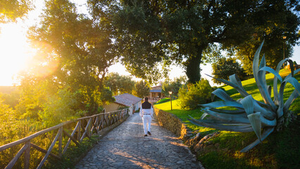 A men dressed in old money style walks to the villa in italy during golden hour on Tuscany countryside with beautiful sunlight evokes dolce vita, slow life and relax far from hustle