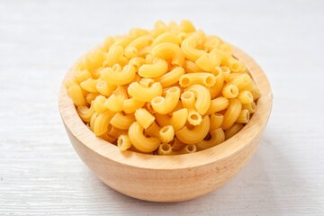 Chifferi rigati pasta in wooden bowl on white background