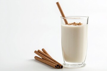 Creamy horchata beverage in glass with cinnamon and straw on white background still life