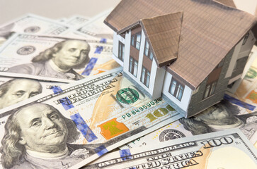 House model on the background of US dollar banknotes. The concept of housing market, buying or...