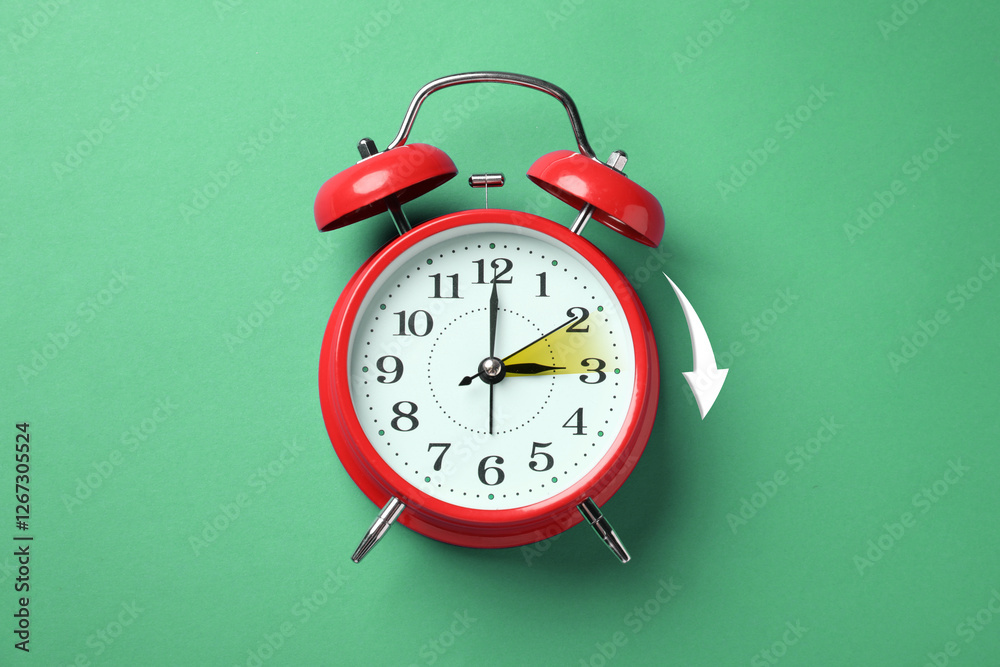 Poster Daylight saving time. Red alarm clock on green background, top view. Highlighted area and arrow showing time change by one hour forward