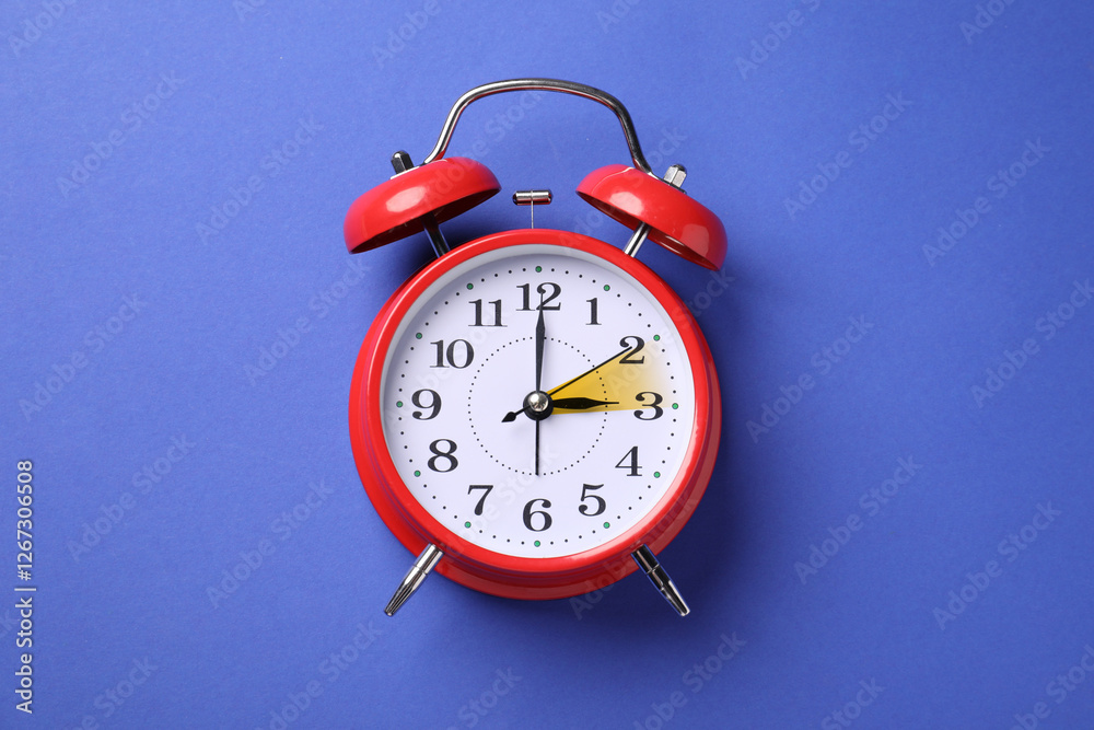 Poster Daylight saving time. Red alarm clock on blue background, top view. Highlighted area showing time change by one hour forward