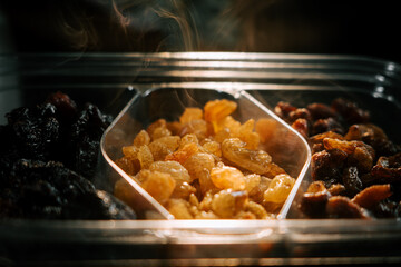 Dried raisins displayed in an illuminated container showcasing their rich colors and tempting aroma