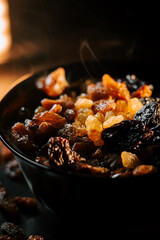 Bowl of assorted raisins garnished with steam against a soft-lit background