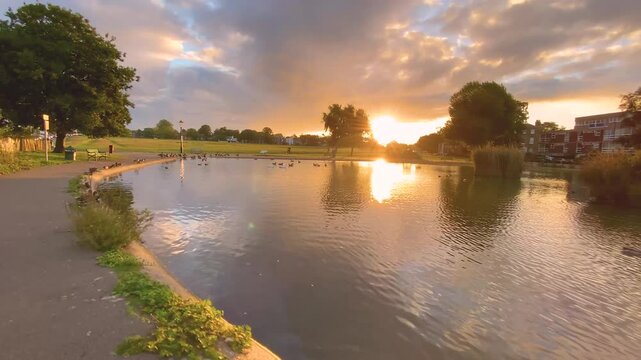 Golden Sunrise Over Folly Pond in Blackheath Village, London &ndash; A serene morning with calm Waters, ducks, and gentle reflections