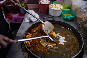 Chef Preparing a Dish by Cracking an Egg into a Pan