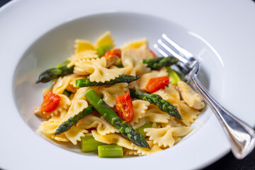 Farfalle pasta with green asparagus, cherry tomatoes and chicken