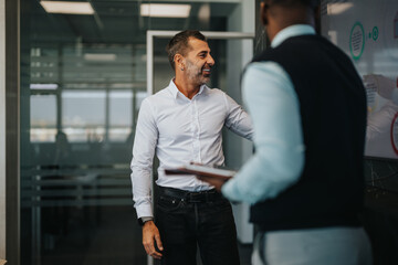 Two business people, engaging in a professional meeting. The scene conveys teamwork, collaboration, and a positive work environment in a modern office setting.