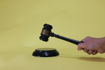 The judge holds a gavel and hits a wooden stand in the courtroom—concept: legal content, law, and...