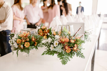 Vases with flowers used at weddings placed on a white table. Blurred background. Bouquets of flowers