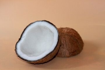 Coconut with half and leaves on orange background