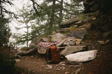 Backpack and picnic blanket on a rock in the forest