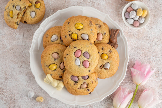 Easter cookies. Tradition american cookies with chocolate mini eggs candy on a white plate. Easter dessert. Copy space.