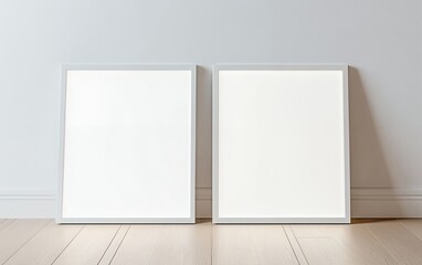 Minimalist set of two blank white frames leaning against a neutral wall on a wooden floor creating a clean and elegant mockup for art prints posters and branding presentations