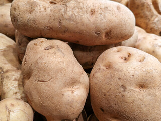 Close Up of Stacked Raw Potatoes at Market Under Bright Lighting