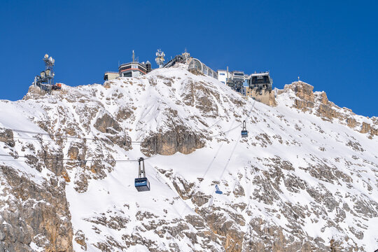Stunning view of the Zugspitze peak from Zugspitzplatt with the cable car to the top station on a sunny winter day, Garmisch-Partenkirchen, Bavaria, Germany