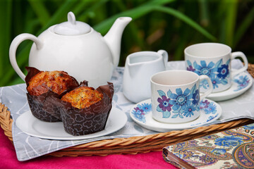 muffins with tea cup set on a tray served in the garden,