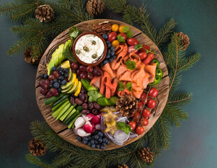 Christmas food Antipasto. Smoked salmon and vegetables with olives at serving board.