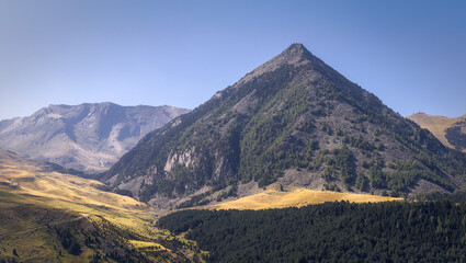 Fototapeta premium Majestic Cerler Peak Towers Over the Lush Valleys of Benasque in Bright Daylight, Spain