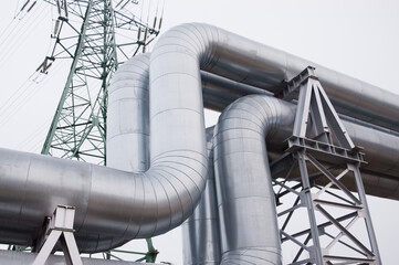 pipeline against a gray sky, power transmission tower in the background