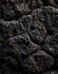 Close-up of porous volcanic rock with a rough and irregular surface, featuring dark tones, natural patterns, and geological formations.
